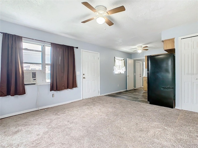 spare room with cooling unit, carpet floors, a textured ceiling, and ceiling fan