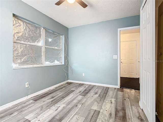 empty room featuring light hardwood / wood-style floors, a textured ceiling, and ceiling fan