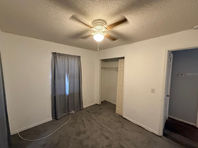 unfurnished bedroom with baseboards, dark carpet, ceiling fan, and a closet