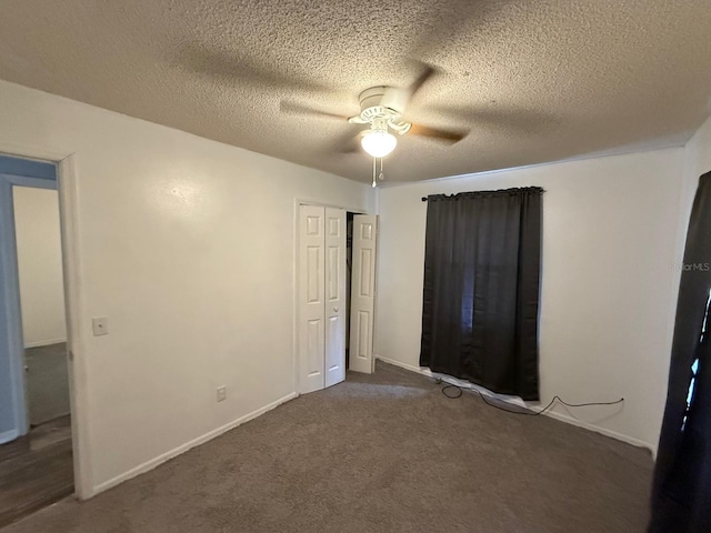 unfurnished bedroom with a ceiling fan, a closet, dark carpet, and a textured ceiling