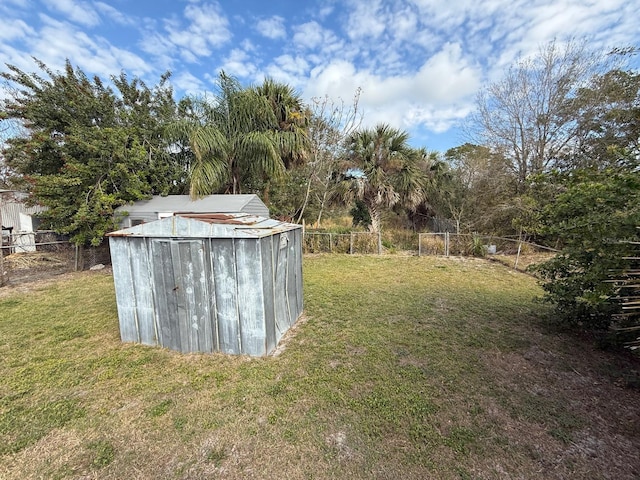 view of yard featuring a fenced backyard, a storage unit, and an outdoor structure