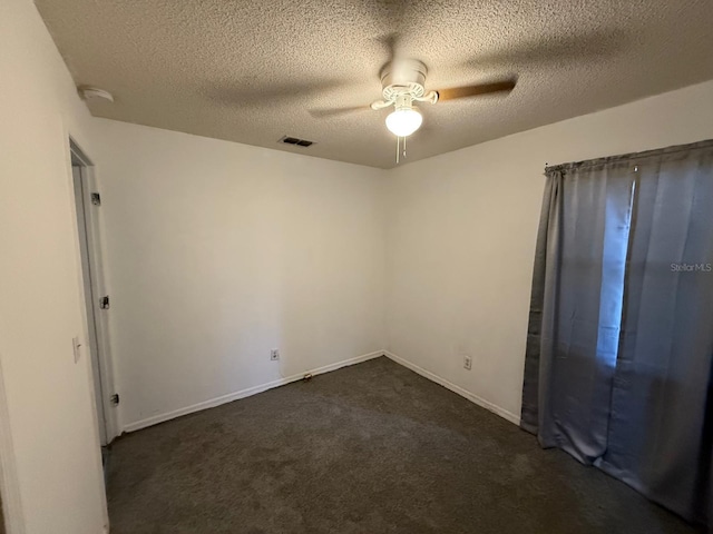 unfurnished bedroom featuring visible vents, baseboards, ceiling fan, dark colored carpet, and a textured ceiling