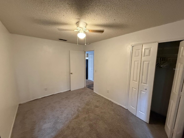 unfurnished bedroom featuring carpet, a textured ceiling, ceiling fan, and a closet