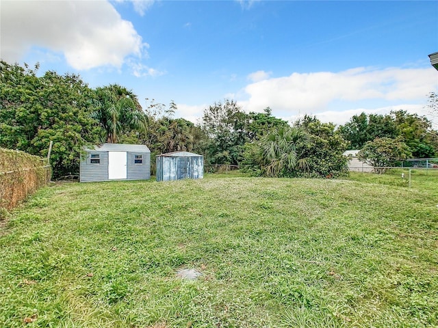 view of yard with a shed, an outdoor structure, and a fenced backyard