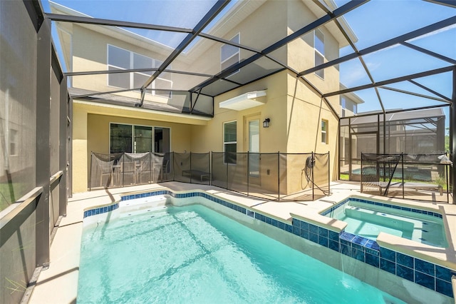 view of pool with an in ground hot tub, a patio, and glass enclosure