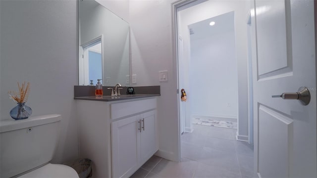 bathroom with toilet, vanity, and tile patterned floors