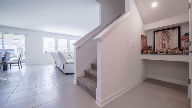 stairs featuring tile patterned flooring and lofted ceiling