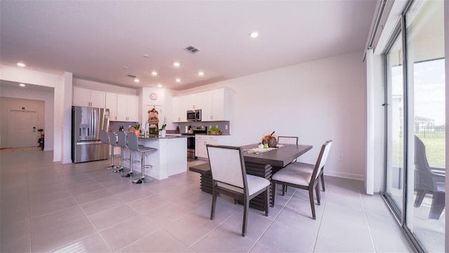 tiled dining space with a healthy amount of sunlight