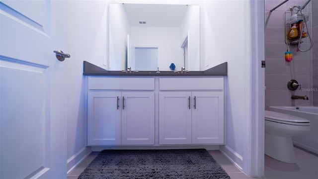 full bathroom with toilet, tiled shower / bath, tile patterned floors, and vanity