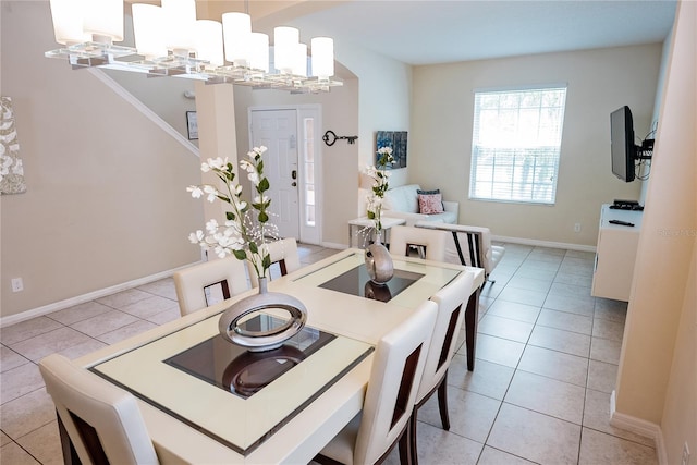 tiled dining room with a chandelier