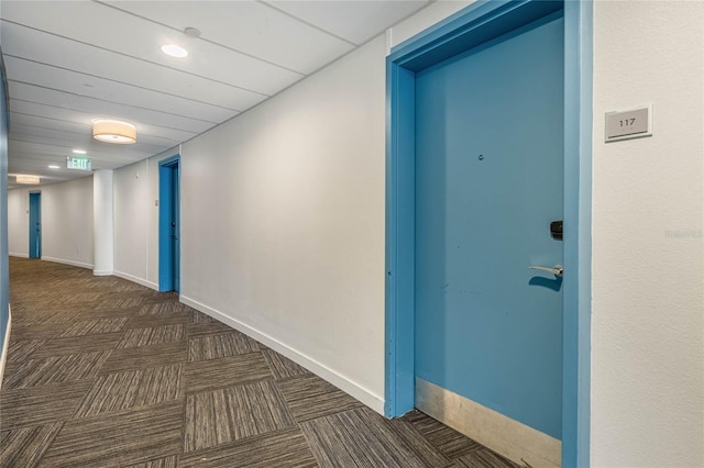 hall with dark colored carpet