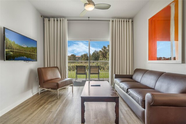 living room with a healthy amount of sunlight, baseboards, wood finished floors, and ceiling fan