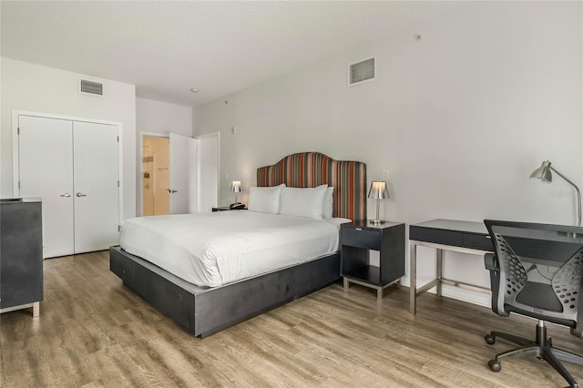 bedroom featuring wood finished floors and visible vents