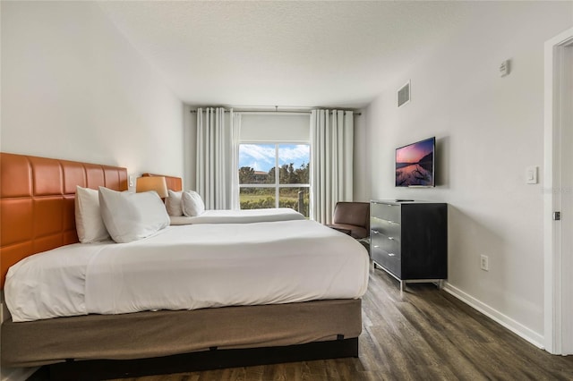 bedroom featuring dark wood-type flooring and a textured ceiling