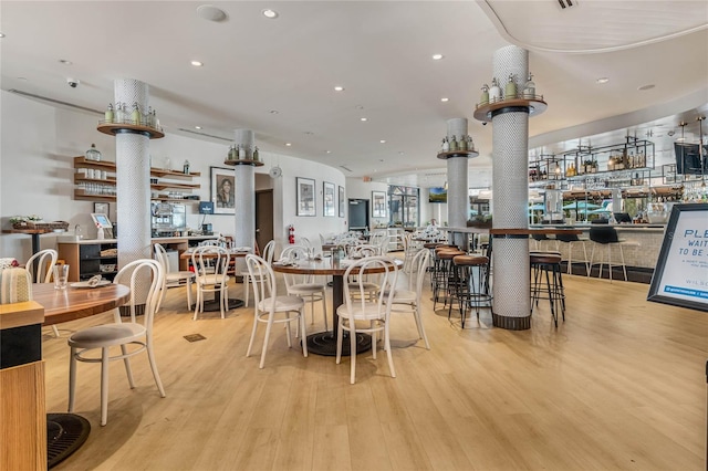 dining room with decorative columns, light wood-style flooring, and recessed lighting