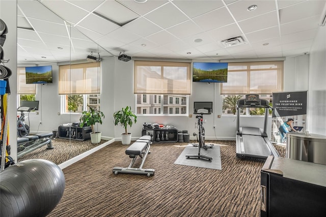 exercise room featuring carpet, a drop ceiling, visible vents, and baseboards