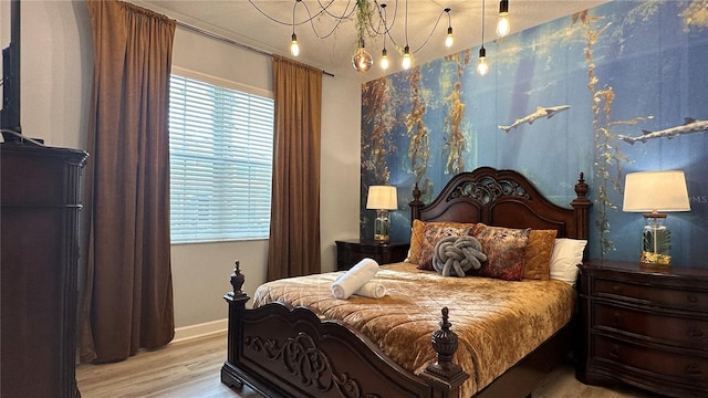 bedroom featuring light hardwood / wood-style floors and a chandelier