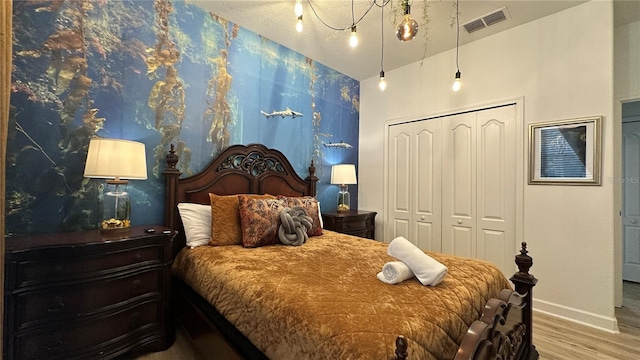 bedroom with a closet, wood-type flooring, and vaulted ceiling