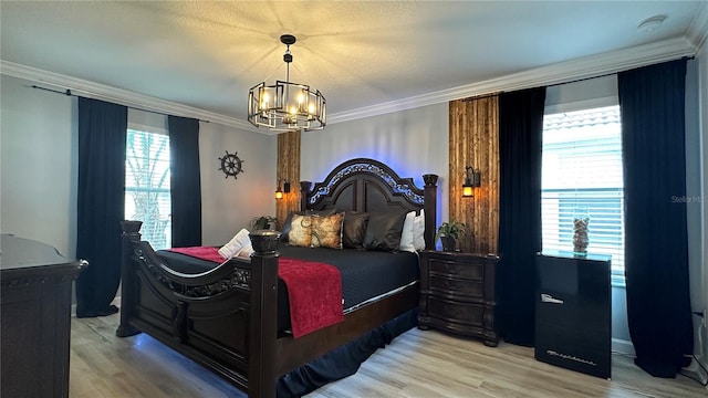 bedroom featuring light hardwood / wood-style floors, crown molding, and an inviting chandelier