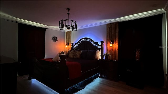 home theater room featuring crown molding, hardwood / wood-style floors, and a chandelier