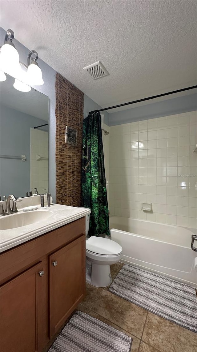 full bathroom featuring toilet, tile patterned flooring, shower / bath combination with curtain, vanity, and a textured ceiling