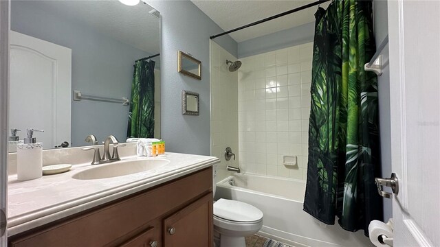 full bathroom featuring shower / bath combination with curtain, toilet, a textured ceiling, and vanity