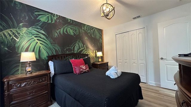 bedroom with light hardwood / wood-style floors, a closet, and a textured ceiling