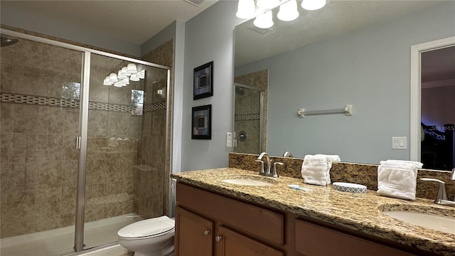 bathroom featuring vanity, a textured ceiling, walk in shower, and toilet