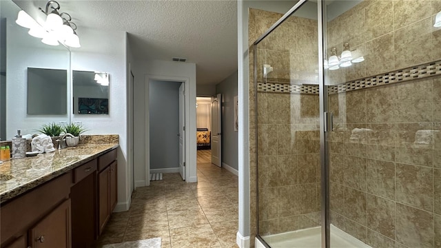 bathroom featuring vanity, a textured ceiling, tile patterned flooring, and a shower with door