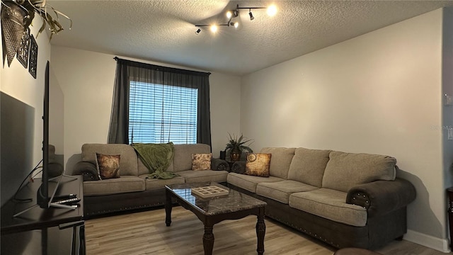 living room featuring light hardwood / wood-style flooring and a textured ceiling