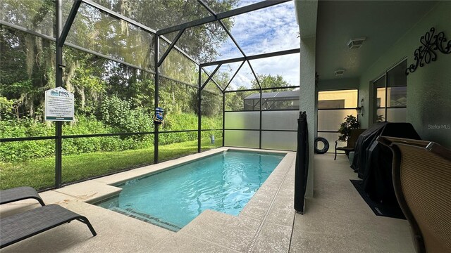 view of pool with a patio area and a lanai