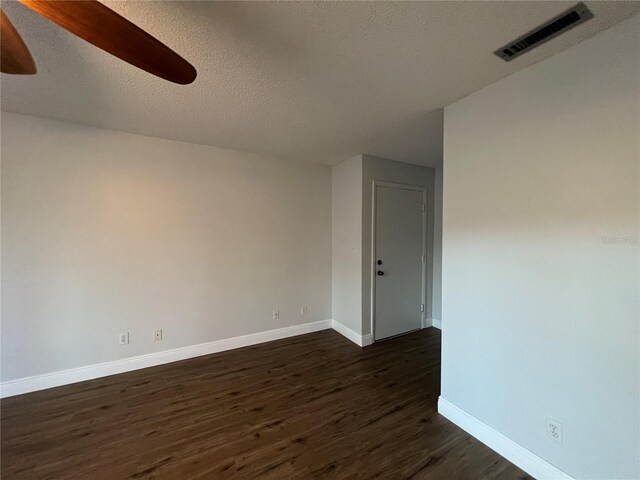 unfurnished room with dark wood finished floors, baseboards, a ceiling fan, and a textured ceiling