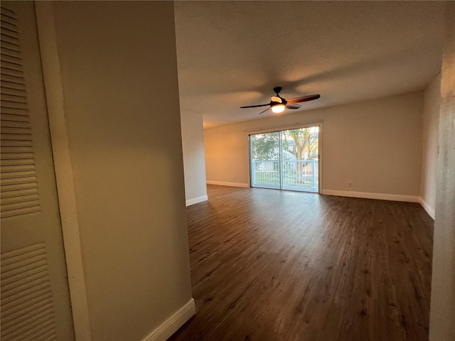 unfurnished room with baseboards, dark wood finished floors, and a ceiling fan