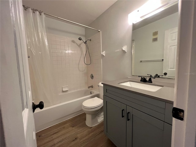 bathroom with wood finished floors, toilet, vanity, and shower / tub combo