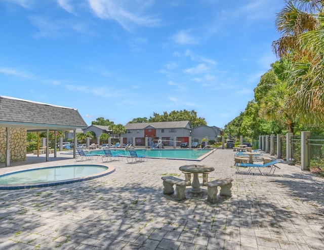 community pool featuring fence and a patio area