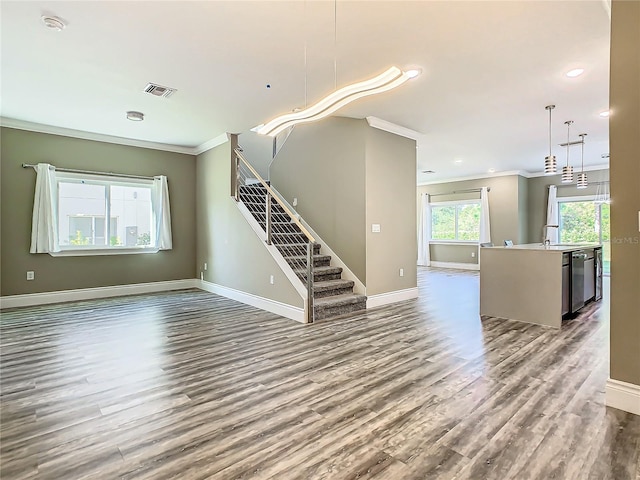 unfurnished living room featuring ornamental molding and wood-type flooring