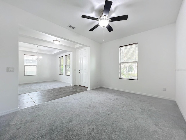 empty room with ceiling fan with notable chandelier and carpet floors