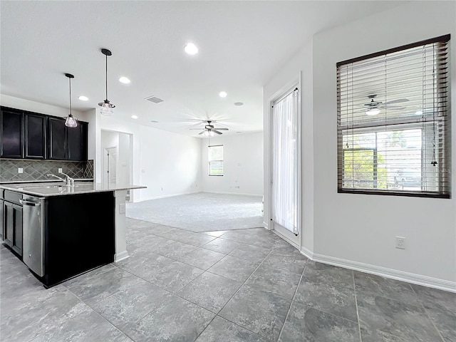 kitchen with pendant lighting, plenty of natural light, ceiling fan, and a center island with sink