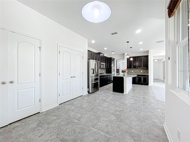 kitchen with backsplash, stainless steel appliances, pendant lighting, a kitchen island, and a breakfast bar area