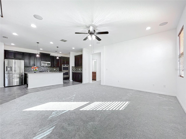 unfurnished living room with ceiling fan, light colored carpet, and a textured ceiling