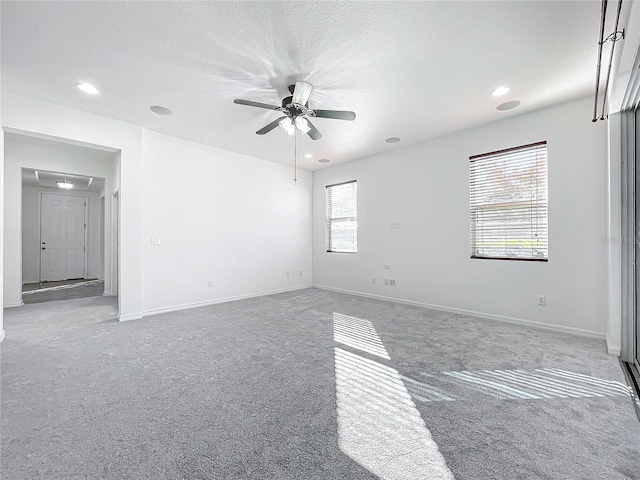 carpeted spare room featuring ceiling fan and a textured ceiling