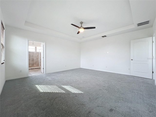 carpeted empty room with a tray ceiling and ceiling fan