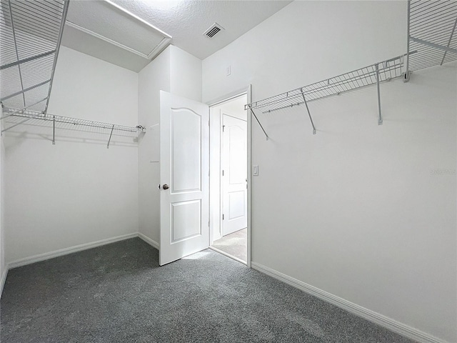 spacious closet featuring dark carpet