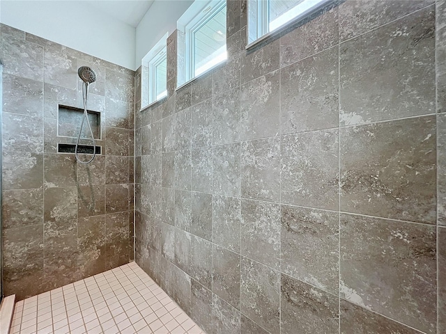 bathroom with a tile shower and a wealth of natural light