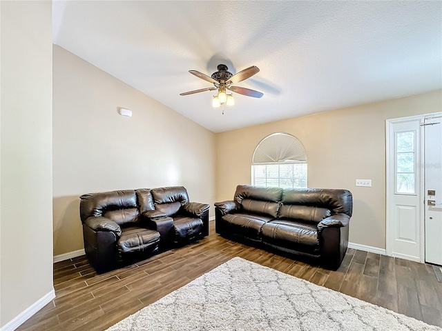 living room with ceiling fan, a healthy amount of sunlight, lofted ceiling, and dark hardwood / wood-style floors