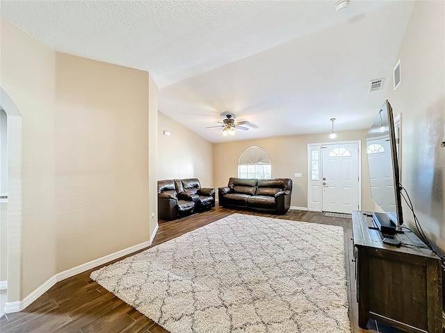 living room with ceiling fan, a textured ceiling, and dark hardwood / wood-style floors