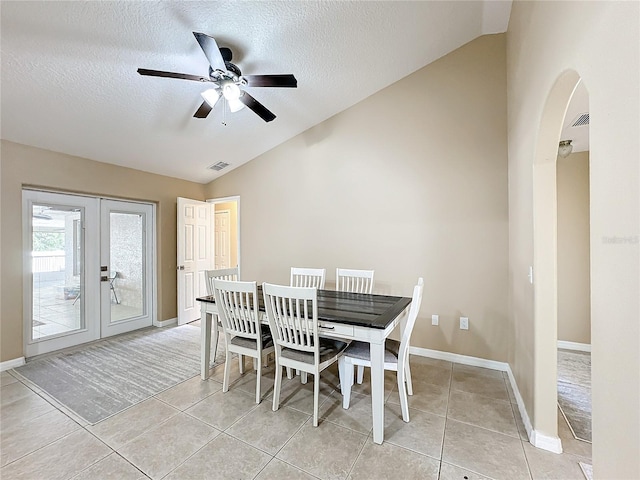 dining space featuring french doors, a textured ceiling, ceiling fan, lofted ceiling, and light tile patterned floors