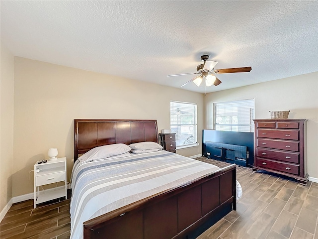 bedroom with ceiling fan, a textured ceiling, and light hardwood / wood-style floors