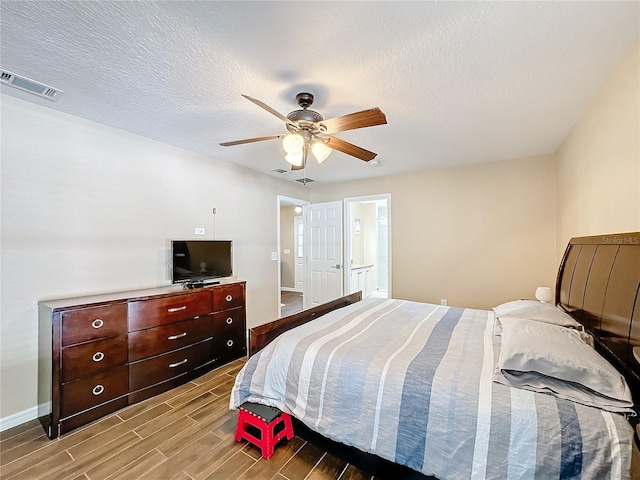 bedroom with connected bathroom, light hardwood / wood-style floors, a textured ceiling, and ceiling fan