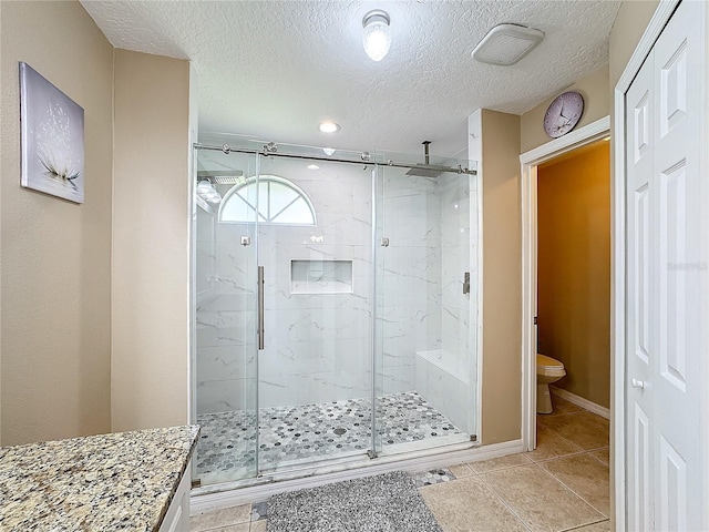 bathroom featuring toilet, an enclosed shower, vanity, and tile patterned flooring